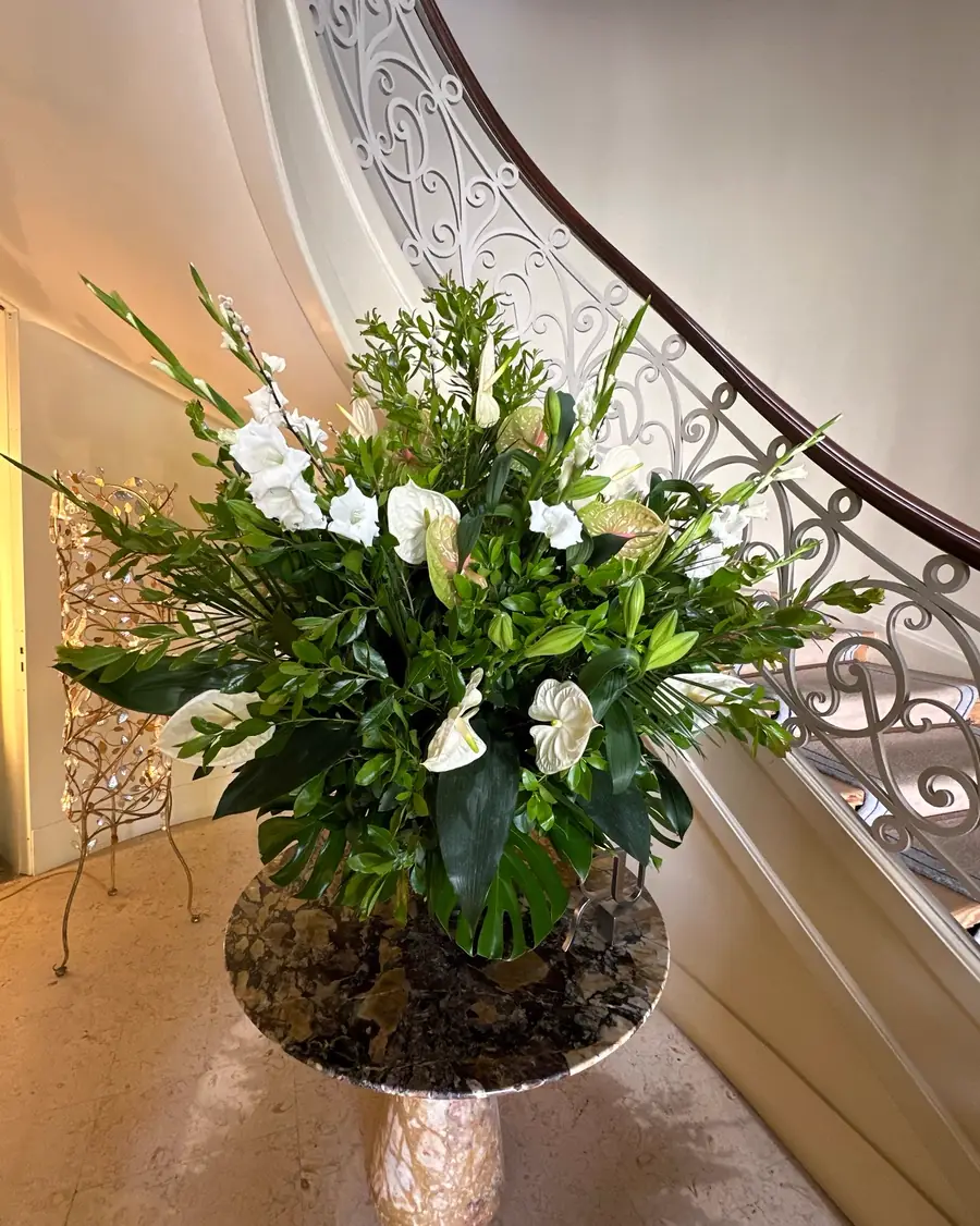Aranjament floral generos cu crini albi, într-un hol elegant