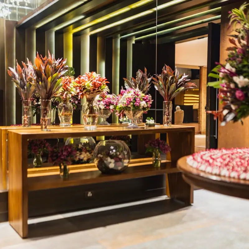 Aranjamente florale pe o masă lungă, la o recepție corporate