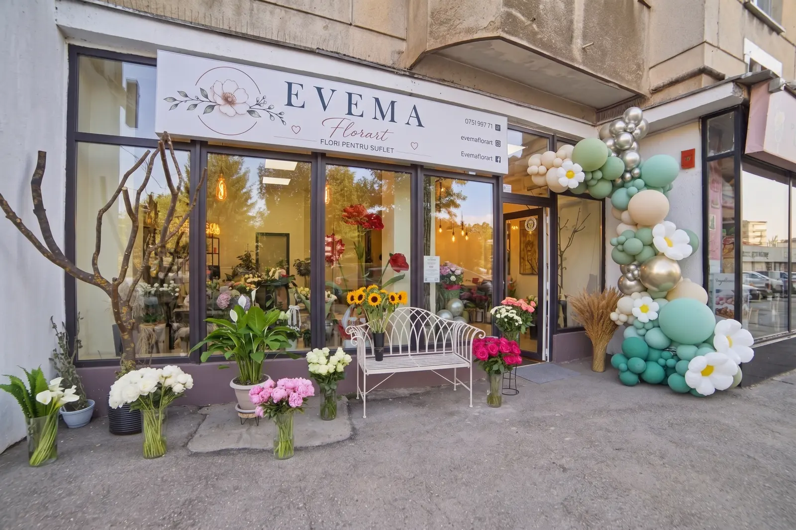 Vitrina magazinului EVEMA Florart, decorată cu arcadă de baloane și flori
